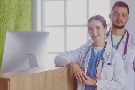 Young doctors are standing inside the hospital and looking at cameraの写真素材