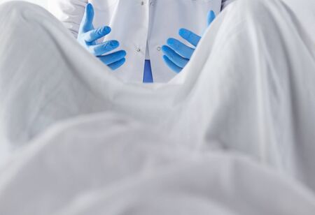 male obstetrician and scrubs nurse are delivered to the pregnant woman in the delivery room of the hospital.の写真素材