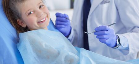 Little girl sitting in the dentists officeの写真素材