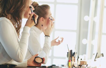 make up artist doing professional make up of young womanの写真素材
