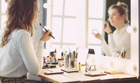 make up artist doing professional make up of young womanの写真素材