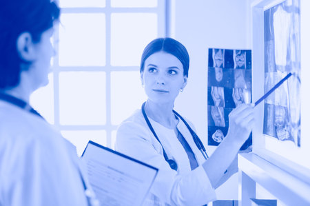 Two female doctors looking at x-rays in a hospital