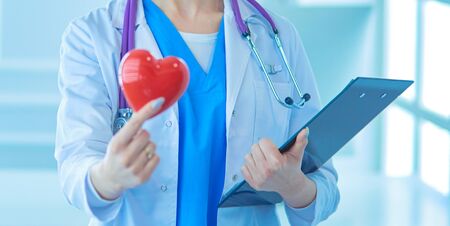 Female doctor with the stethoscope holding heart.の写真素材