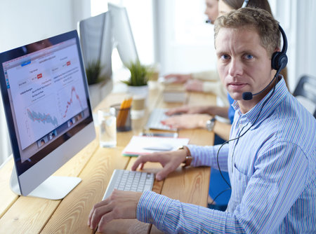 Attractive positive young businesspeople and colleagues in a call center office