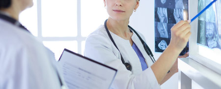Two female doctors discussing medical problems and checking x-rays in a hospital