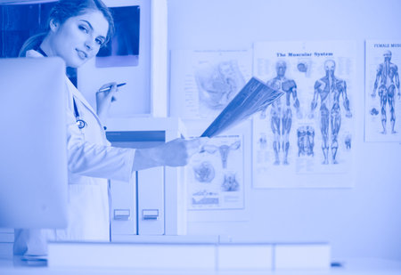 Young professional female doctor examining patients x-ray