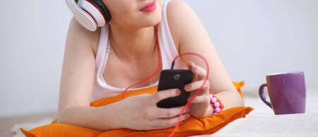 Young woman lying on floor and listen to musicの写真素材