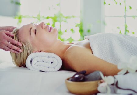Beautiful young woman lying in spa salon.の写真素材