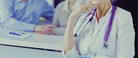 Doctor woman sitting with male patient at the desk.の写真素材