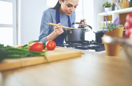 Cooking woman in kitchen with wooden spoonの写真素材