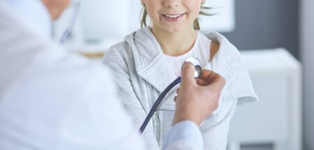 Girl and doctor with stethoscope listening to heartbeat.の写真素材