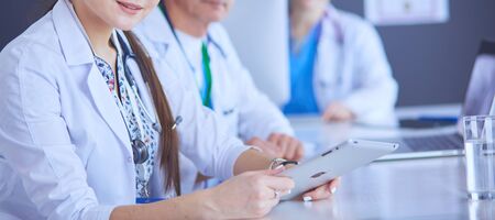 Serious medical team using a laptop in a bright office.の写真素材