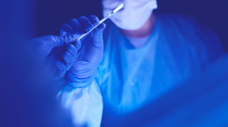 Doctor performing surgery in a dark background