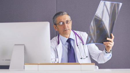close up of male doctor holding x-ray or roentgen image