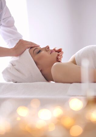Young woman lying on a massage table,relaxing with eyes closed. Woman. Spa salonの写真素材