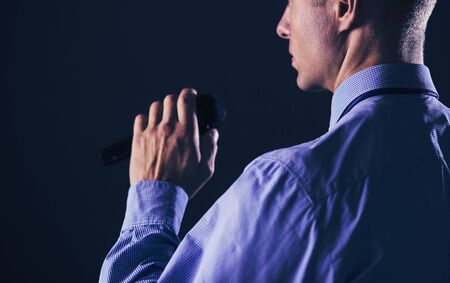 Businessman speech concept, talking with microphone in conference hall.の写真素材