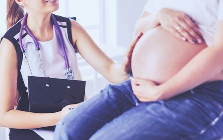 Young female doctor examining pregnant woman at the clinic.の写真素材