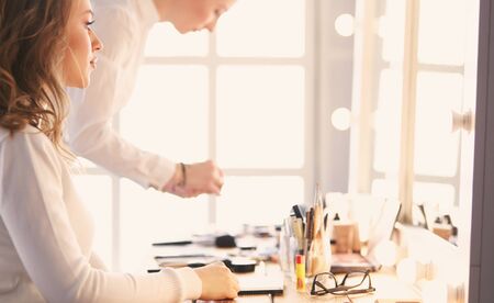 make up artist doing professional make up of young woman.の写真素材