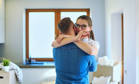 Happy couple hugging in their new houseの写真素材