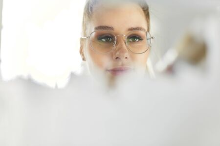 Happy young family painting a wall with white paintの写真素材