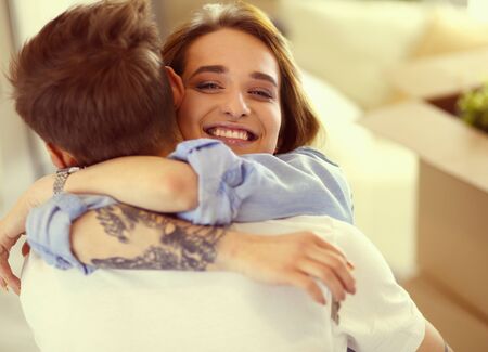 Happy couple hugging in their new houseの写真素材
