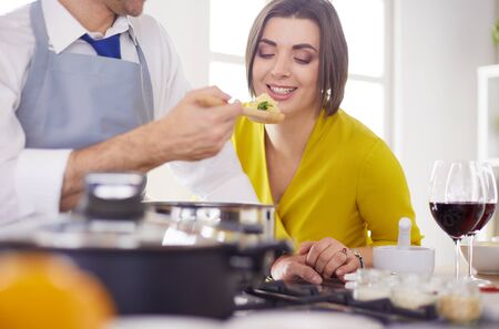 Couple cooking together in the kitchen at homeの写真素材