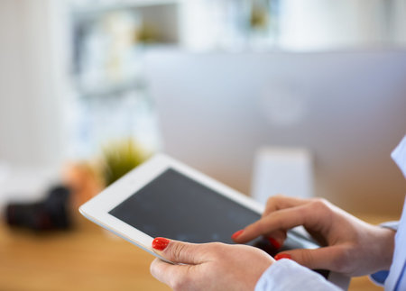 Portrait of an attractive professional photographer woman and using a tablet