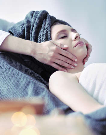 Young woman lying on a massage table,relaxing with eyes closed. Woman. Spa salonの写真素材