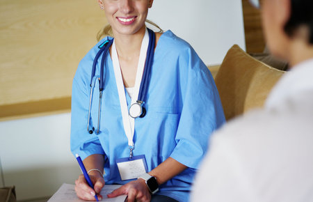Female doctor talking to patient sitting in medical officeの写真素材