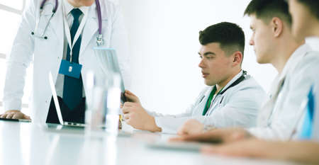 Medical team sitting and discussing at tableの写真素材