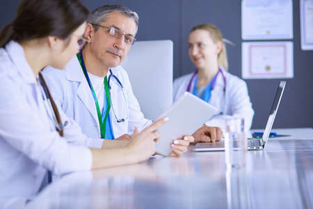 Serious medical team using a laptop in a bright officeの写真素材