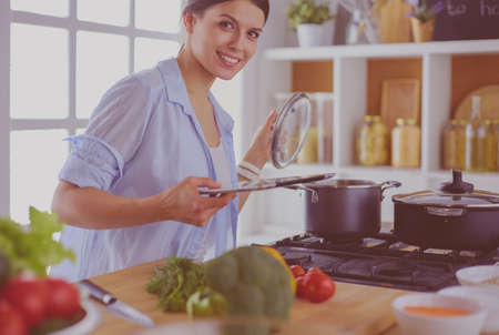 Young woman using a tablet computer to cook in her kitchen.の写真素材