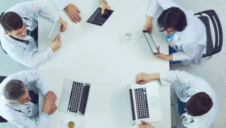 Medical team sitting and discussing at table, top viewの写真素材