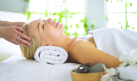 Beautiful young woman lying in spa salonの写真素材