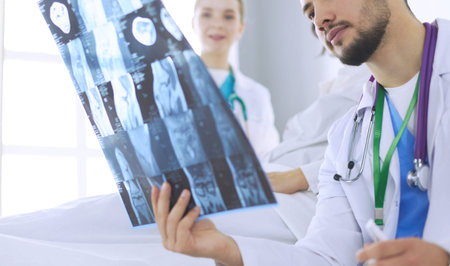 Attractive doctor examining an x-ray and smiling at the camera