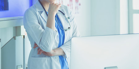 Young woman medic in white uniform standing in clinics office