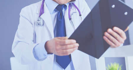Male doctor writes notes on the clipboard in the hospitalの写真素材