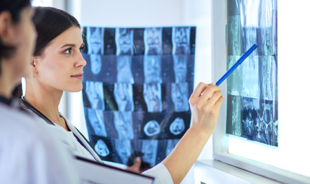 Two female doctors pointing at x-rays in a hospitalの写真素材