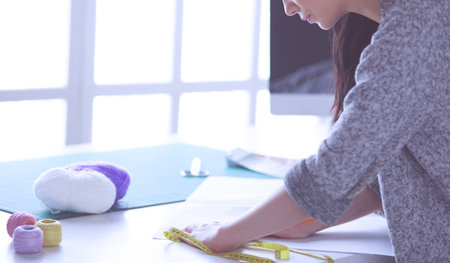 Woman American fashion designer working in atelier.