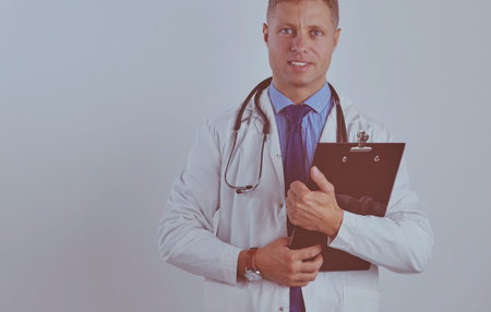 Male doctor standing with folder, isolated on white background