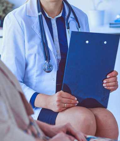 Doctor and patient discussing something while sitting at the table . Medicine and health care conceptの写真素材