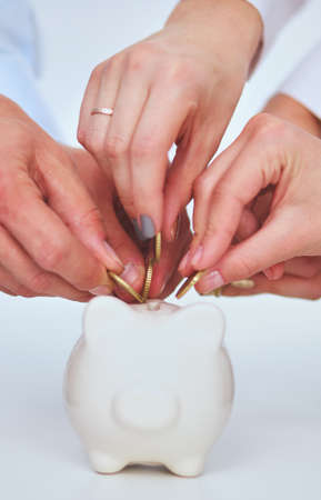 People putting coin into the piggy bankの写真素材