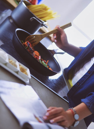 Young woman in the kitchen preparing a foodの写真素材