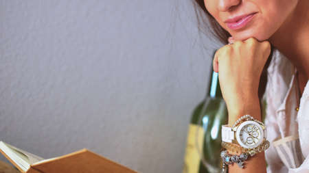 Young woman sitting a table in the kitchen. Young womanの写真素材