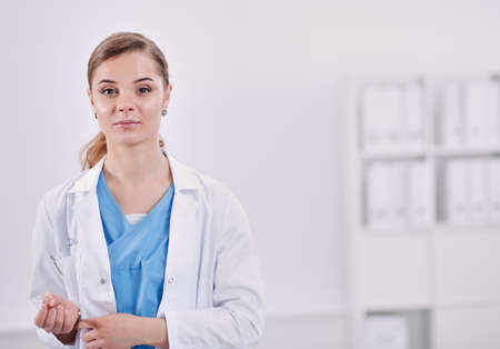 Woman doctor standing with folder at hospitalの写真素材