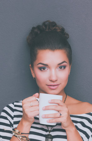Portrait of young woman with cup tea or coffeeの写真素材