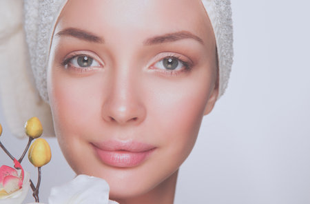 Portrait of beautiful girl touching face with a towel on her headの写真素材