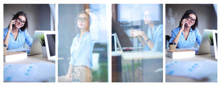 Beautiful young business woman sitting at office desk and talking on cell phoneの写真素材