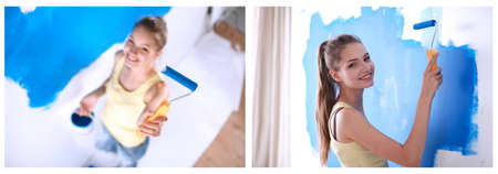 Beautiful young woman doing wall painting , standingの写真素材