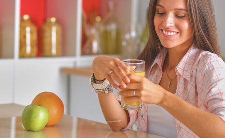 Young woman sitting a table in the kitchen. Young womanの写真素材